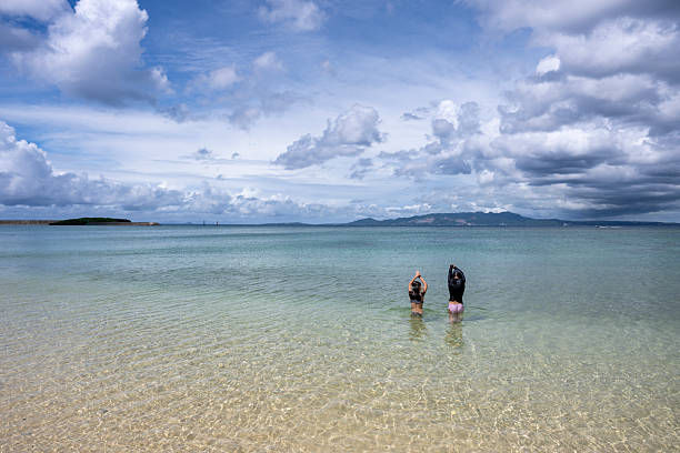 Sisters swim in sea together in calm bay, Onna, Okinawa