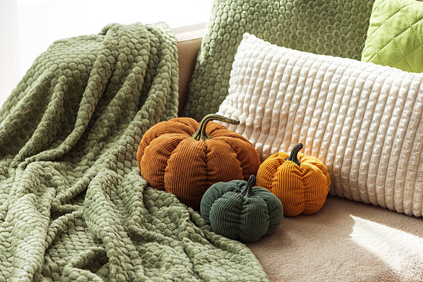 istock Cozy Autumn Sofa with Fabric Pumpkins and Textured Pillows 2237899284