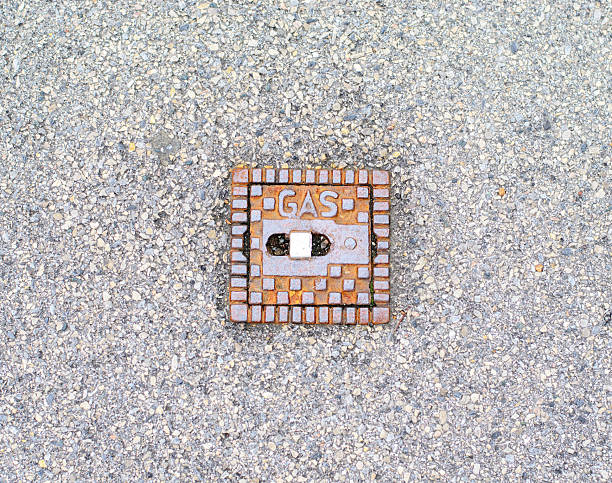 istock Small Rusty Square Gas Valve Cover on Rough Asphalt Background 2237905381