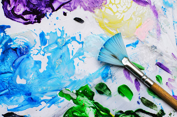 istock Fan brush in blue paint puddle with colorful background 2237905424