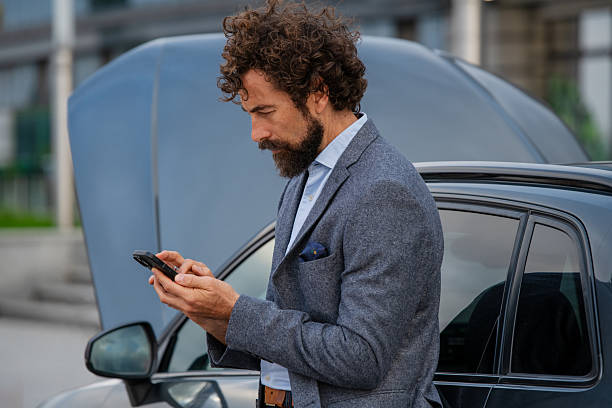 istock Car Trouble: Man on Smartphone Seeking Help with Open Hood 2237909301
