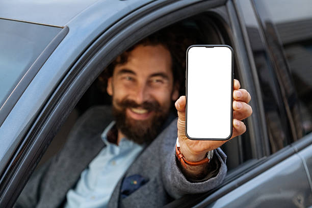 istock Happy Man in Car Holding Smartphone with Blank Screen Mockup 2237909326