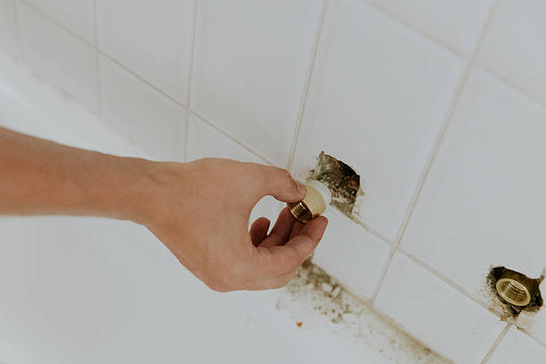 istock A young man takes out a faucet nut from the wall. 2237910235