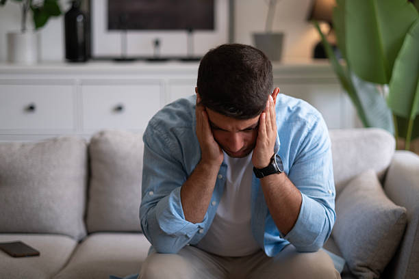 istock Man sitting alone at home looking sad and distraught 2237910606