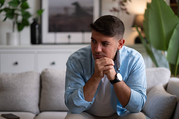 istock Man sitting alone at home looking sad and distraught 2237910608