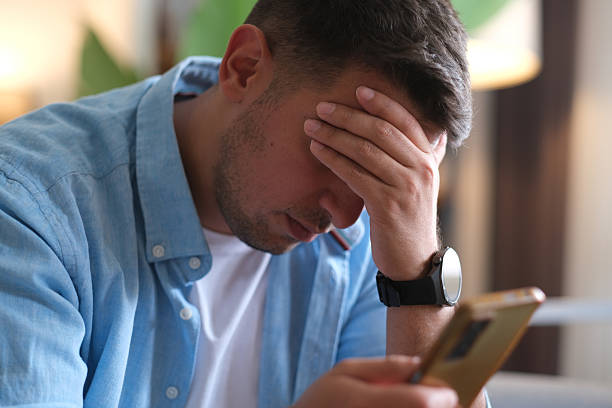 istock Man sitting alone at home looking sad and distraught 2237910611