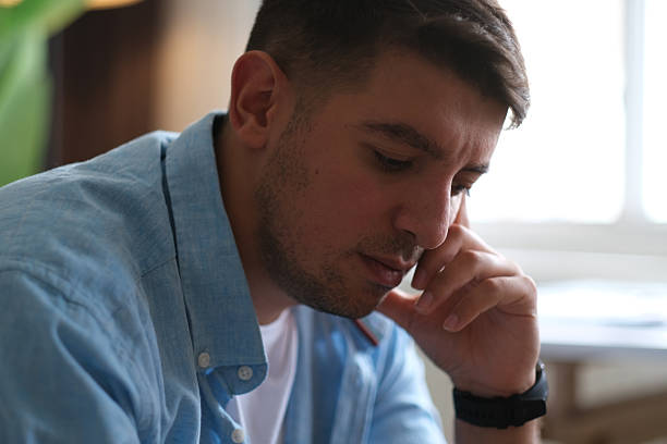 istock Man sitting alone at home looking sad and distraught 2237910713