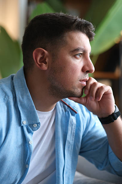 istock Man sitting alone at home looking sad and distraught 2237910897