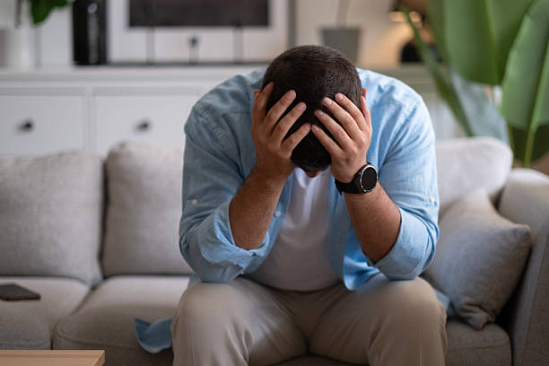 istock Man sitting alone at home looking sad and distraught 2237910977