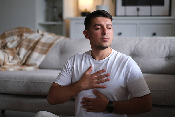 istock Young man meditating at home 2237912034