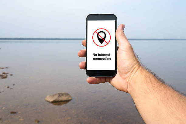 istock Hand holding phone showing no internet connection by lake 2237913391