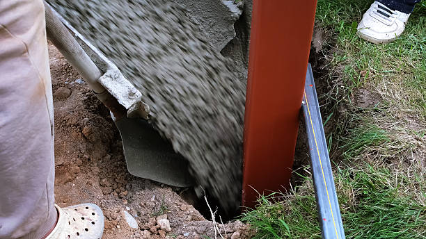 istock A builder pours a wet concrete from a mixer truck into a foundation. Pouring cement into pit with pillar. Foundational work. Workers control a mix flows through the gutter. Building industry 2237913755