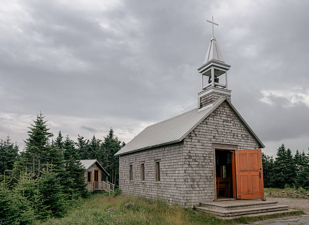 istock Old Wooden Chapel With Bell Tower and Open Door Under Cloudy Sky 2237917246