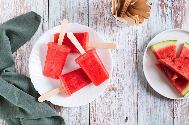 istock Watermelon popsicles on wooden sticks on a plate on a table top view 2237925278