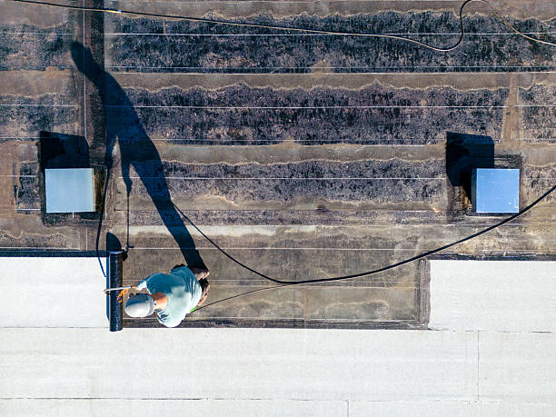 istock Roofer applying torch to bitumen membrane on torch down roof 2237928424