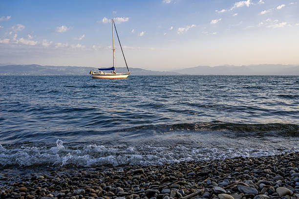 a sailboat floating on the waves along the shore
