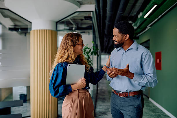 istock Business colleagues discussing project in modern office hallway 2237933547
