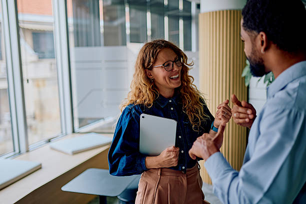 Diverse coworkers laughing during an office discussion