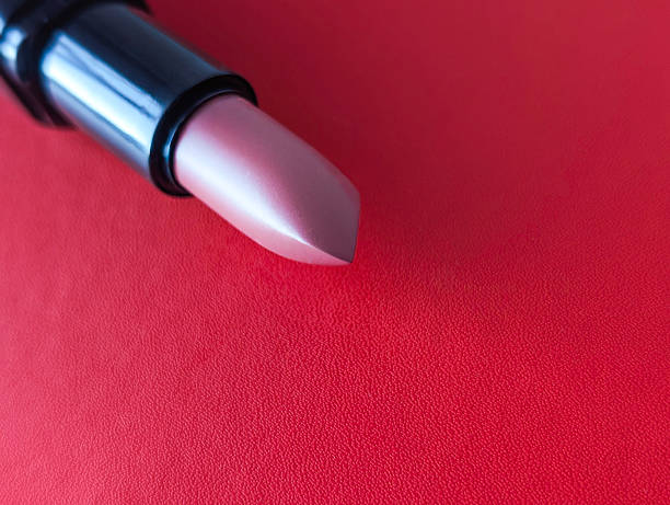 istock Nude lipstick on red background, horizontal close-up 2237933562