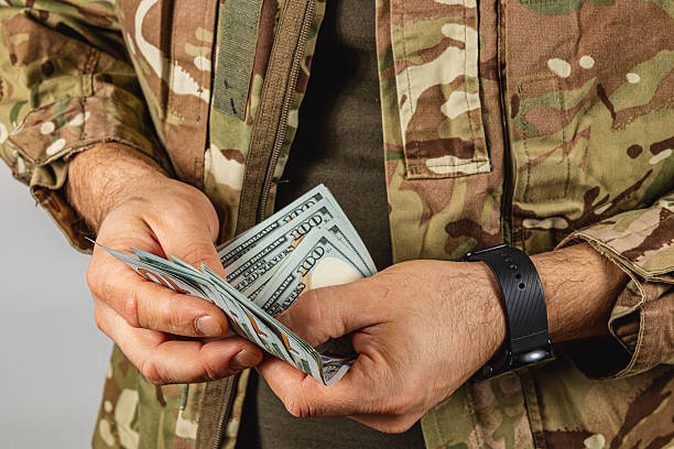istock Soldier counting cash in camouflage uniform indoors 2237936549