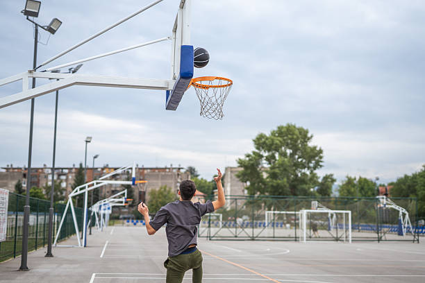 istock Man shooting basketball scoring a point outdoors 2237939061
