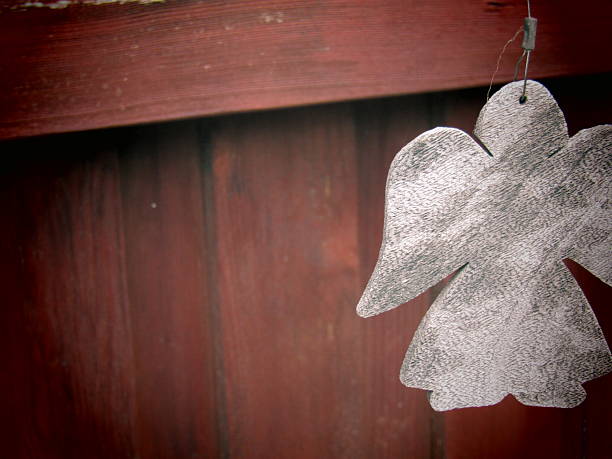 Wooden angel on red fence background