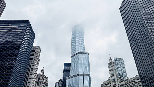 Tall buildings are partially visible in fog. The city skyline shows a mix of glass and steel structures.