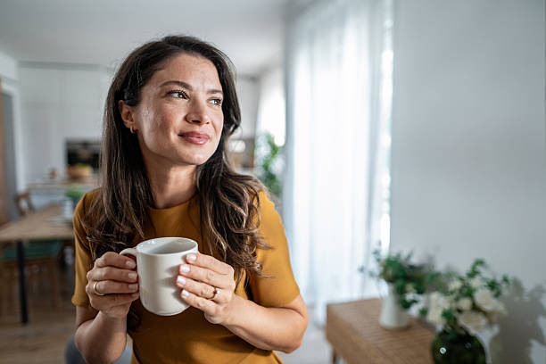 istock Woman holding coffee mug daydreaming at home 2237945845