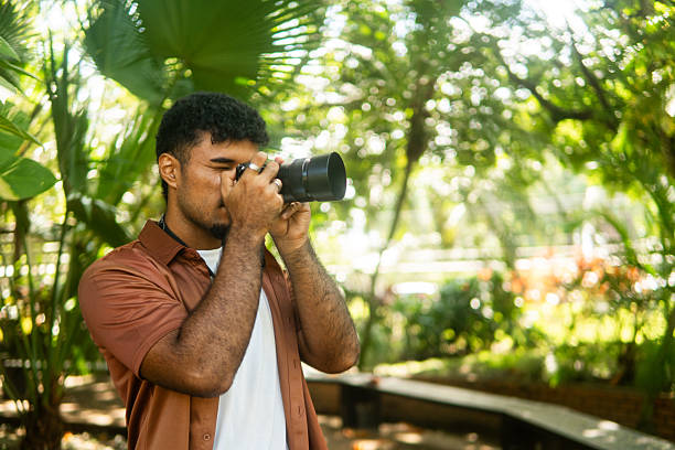 istock Young man taking pictures in nature with camera 2237946817