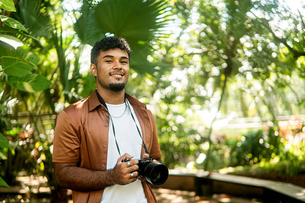istock Young hispanic man enjoying nature while photographing outdoors 2237946818