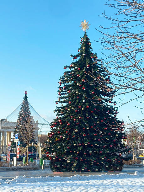 istock Christmas tree adorned with colorful ornaments and a star on top, surrounded by snow, with a clear blue sky and festive atmosphere, capturing holiday spirit and joy 2237948310