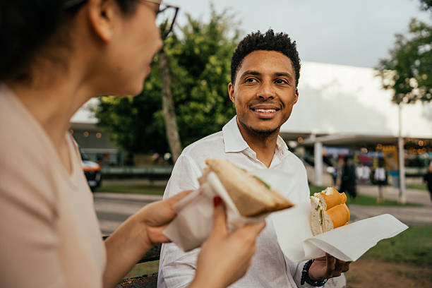istock Couple having a snack on a park bench 2237950018