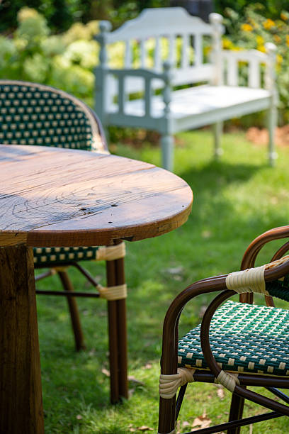 istock Wooden Table and Chairs in a Lush Garden Setting 2237953594