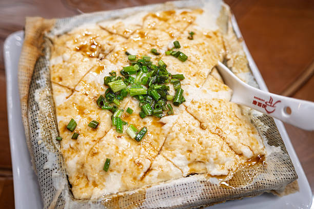 Steamed Tofu with Chopped Green Onions Served on a Mesh Liner