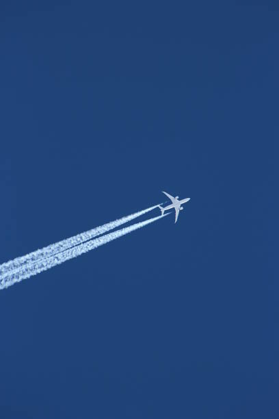 istock Airplane leaving a Contrail in the blue Sky 2237954424