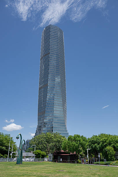 istock A Modern Skyscraper Towering Against a Clear Blue Sky with Lush Greenery Below 2237965116