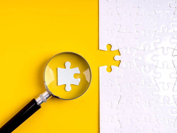 istock Magnifying glass focusing on puzzle piece fitting into missing part. Concept for hiring, human resource selection, recruitment, team building, employee match, workforce planning and business solution. 2237969213