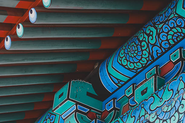 Colorful, intricate patterns adorn the traditional architecture's painted eaves and structural beams, showcasing rich cultural artistry.