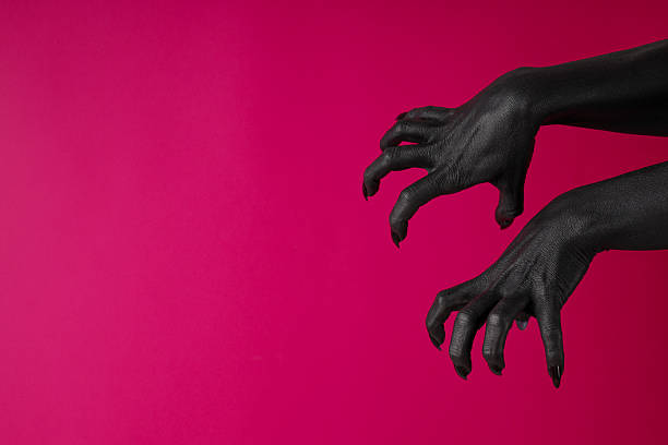 istock Black female hands with black nails on pink background, space for text 2237973957