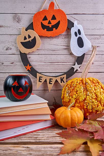 istock Halloween wreath featuring pumpkins, ghosts, jack-o'-lanterns, and books. 2237974853