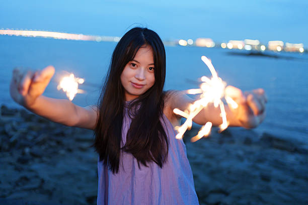 Young people playing with fireworks sticks at the seaside
