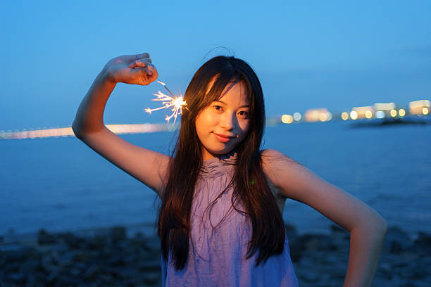 Young people playing with fireworks sticks at the seaside