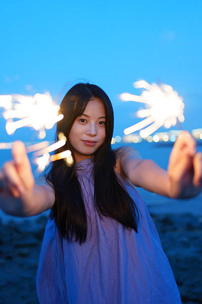 Young people playing with fireworks sticks at the seaside