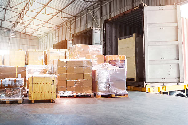 istock Bulk of Package Boxes Waiting to be Loaded into Containers Trucks. Forklift Pallet Jack. Distribution Warehouse, Shipping Cargo Container. Freight Truck Logistics Transportation. 2237978194