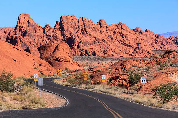 White Domes Road in Valley of Fire State Park, Nevada, USA. The road winds through red and white sandstone formations, desert terrain, and unique geological features.