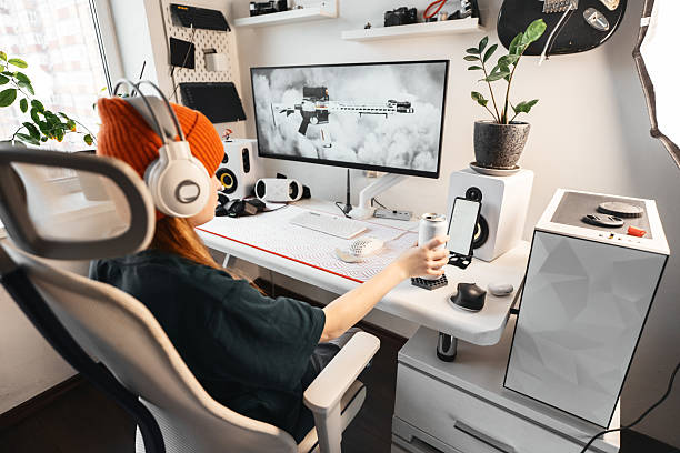 istock Side angle of gaming desk featuring VR headset, high-quality speakers, and modern accessories. Gamer actively plays while interacting with customizable gaming controls for a competitive edge. 2237980220