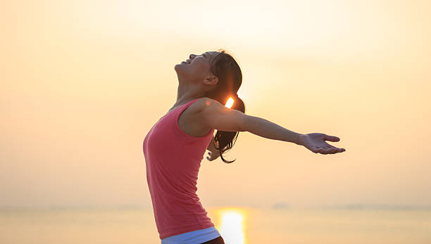 istock Woman open arms under the sunrise at seaside 2237981059