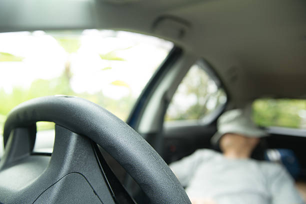 istock Man Resting with Hat on Face in Car Seat 2237981147