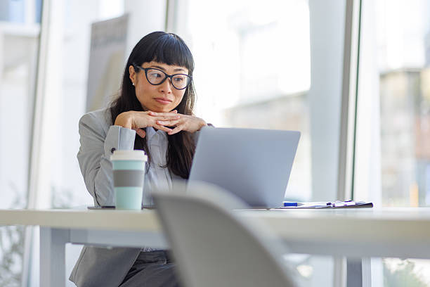 istock Asian businesswoman looking at laptop with pensive expression 2237981264