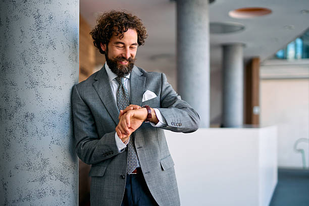 istock Stylish businessman checking time in modern office 2237981410